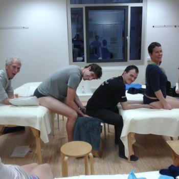 Harvey Burns teaching a Rolfing class to students, smiling and engaged.