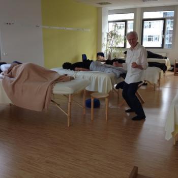 Harvey Burns teaching a Rolfing class to students, smiling and engaged.